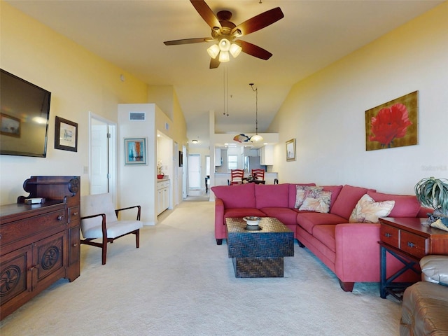 carpeted living room with high vaulted ceiling and ceiling fan