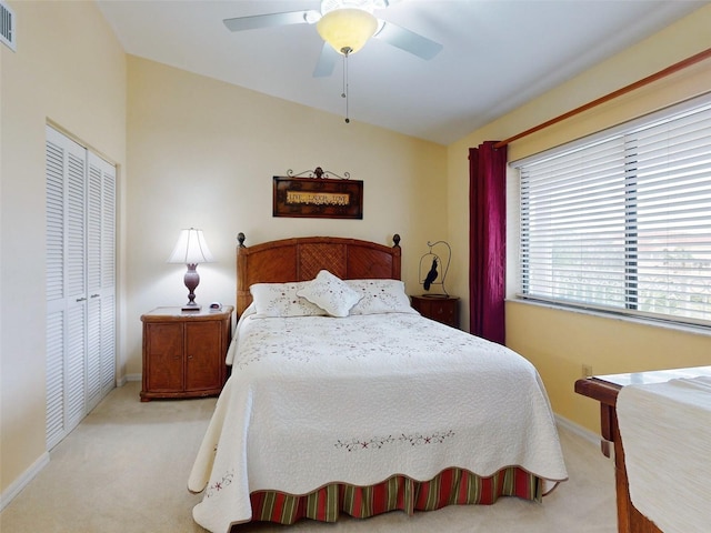 carpeted bedroom featuring ceiling fan and a closet