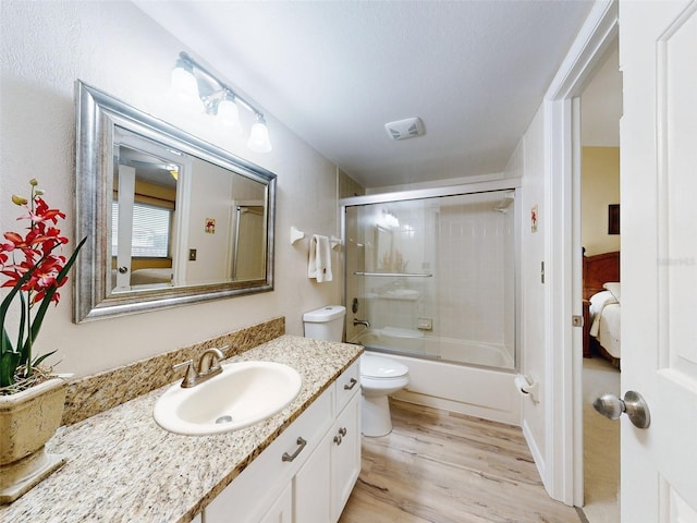 452 Bouchelle Dr Unit 303, New Smyrna Beach, FL 32169 - full bath featuring toilet, wood finished floors, vanity, and shower / bath combination with glass door