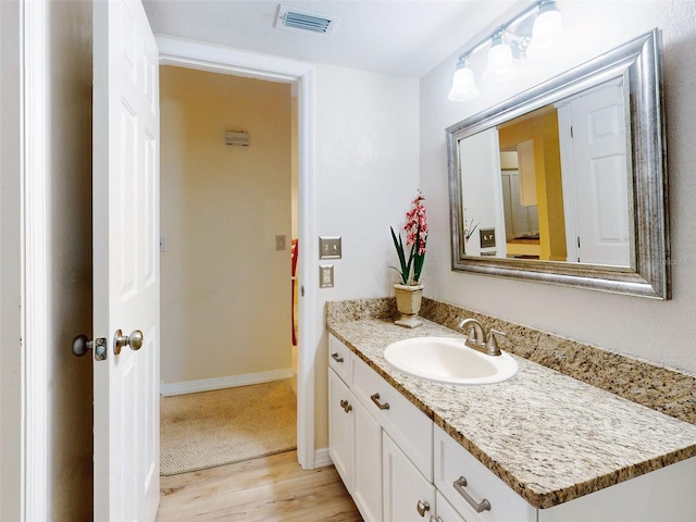 452 Bouchelle Dr Unit 303, New Smyrna Beach, FL 32169 - bathroom with vanity, wood finished floors, and baseboards