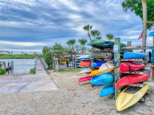 view of jungle gym featuring a water view and a boat dock