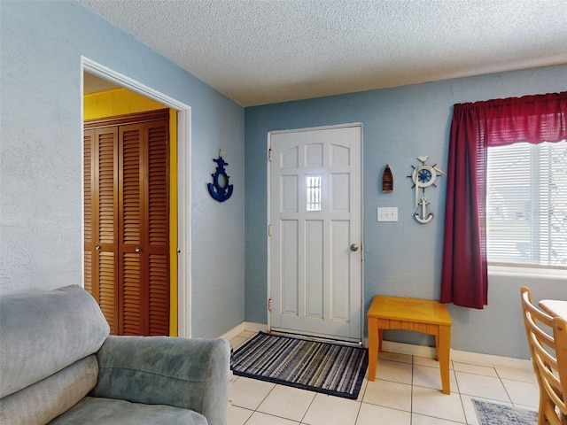 foyer entrance with a textured ceiling and light tile patterned floors