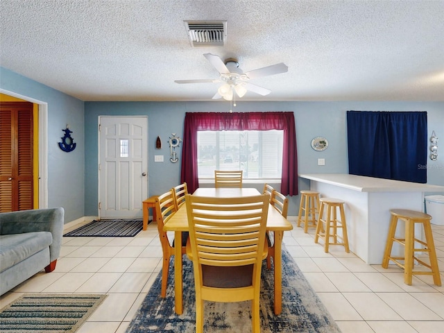 dining room featuring light tile patterned flooring, ceiling fan, and a textured ceiling