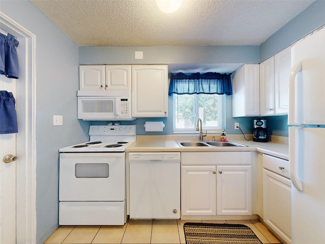 kitchen with light tile patterned flooring, a textured ceiling, sink, white cabinets, and white appliances