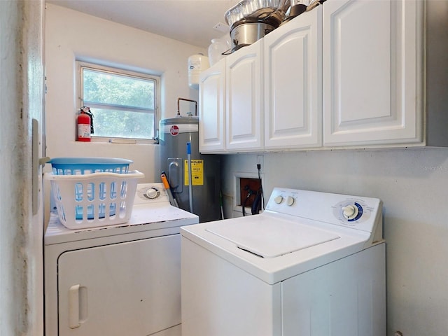 clothes washing area with water heater, cabinets, and washer and clothes dryer