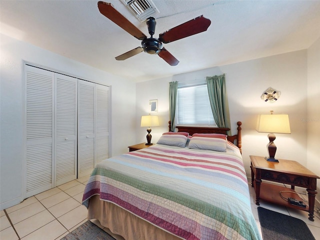 bedroom with a closet, light tile patterned flooring, and ceiling fan