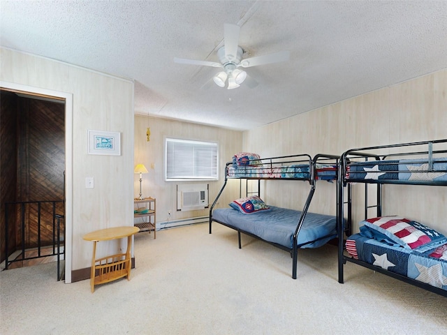 carpeted bedroom with a wall unit AC, ceiling fan, a textured ceiling, and a baseboard heating unit