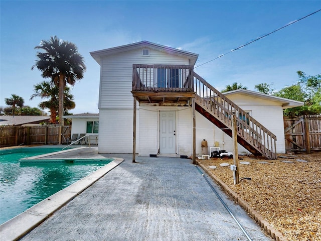 rear view of house with a fenced in pool, a patio, and a sunroom