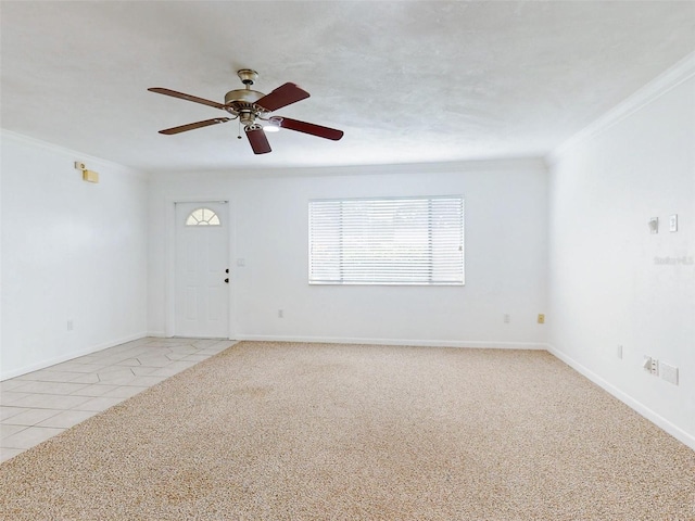 empty room with light tile patterned floors, ceiling fan, and crown molding