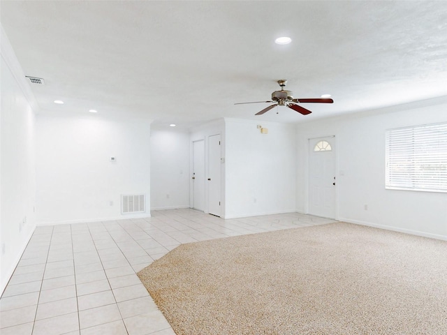 tiled spare room featuring ceiling fan and ornamental molding