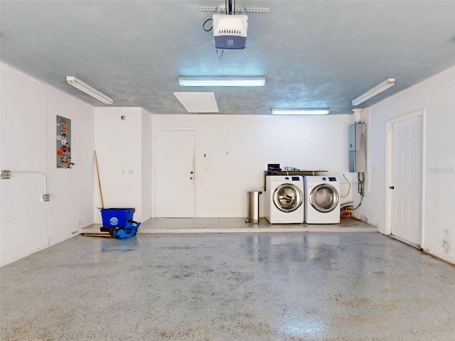 garage with water heater, a garage door opener, and independent washer and dryer