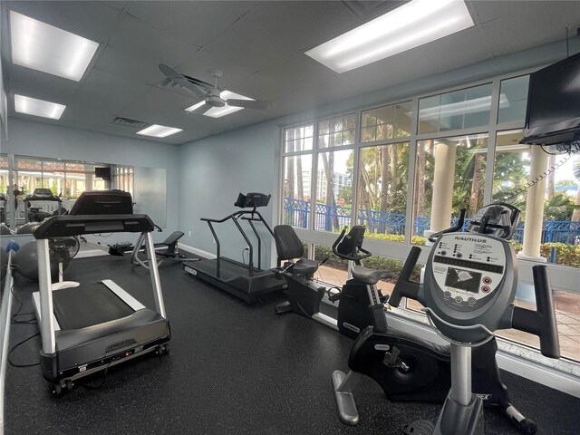 gym with a wealth of natural light, visible vents, baseboards, and ceiling fan