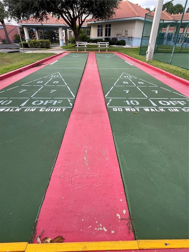 surrounding community featuring shuffleboard, a yard, and fence