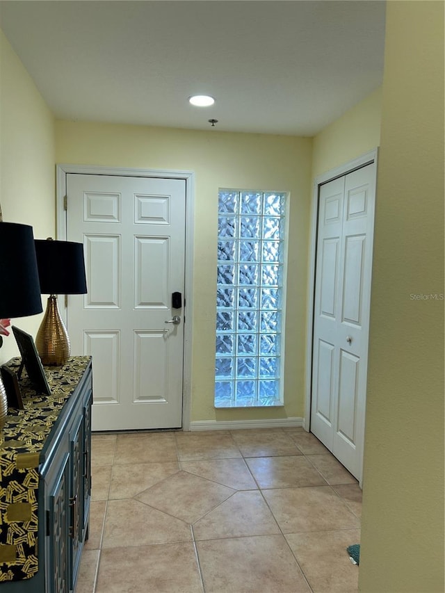 foyer featuring light tile patterned floors and baseboards