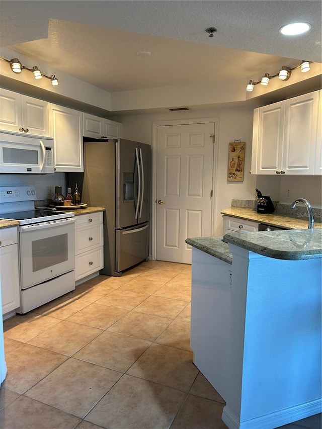 kitchen featuring white cabinets and white appliances