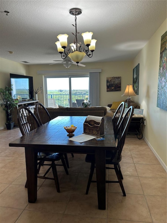 dining space featuring a chandelier, light tile patterned floors, a textured ceiling, and baseboards