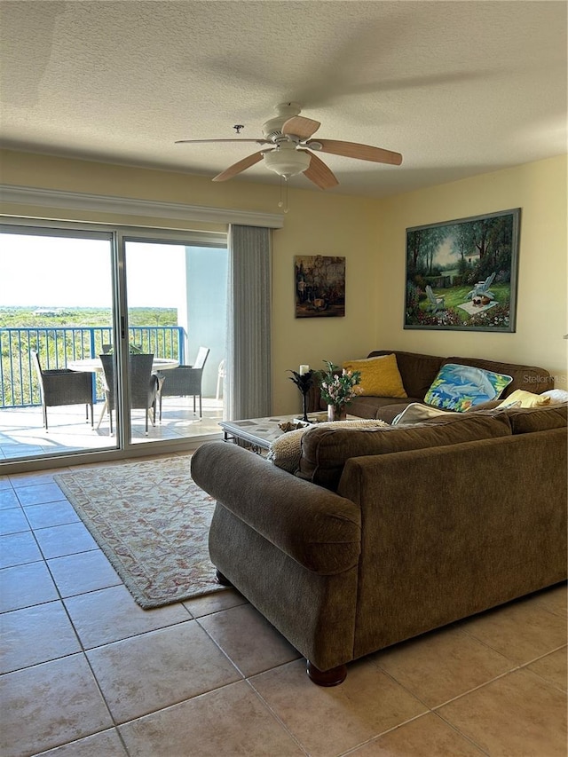 living area featuring light tile patterned floors, a textured ceiling, and ceiling fan