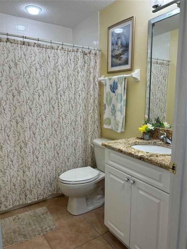 bathroom with tile patterned flooring, toilet, vanity, a shower with curtain, and a textured ceiling