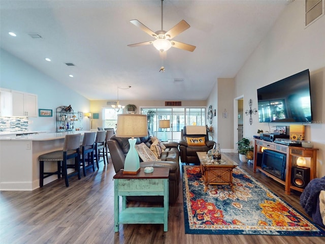 living room with ceiling fan with notable chandelier, dark hardwood / wood-style flooring, and lofted ceiling