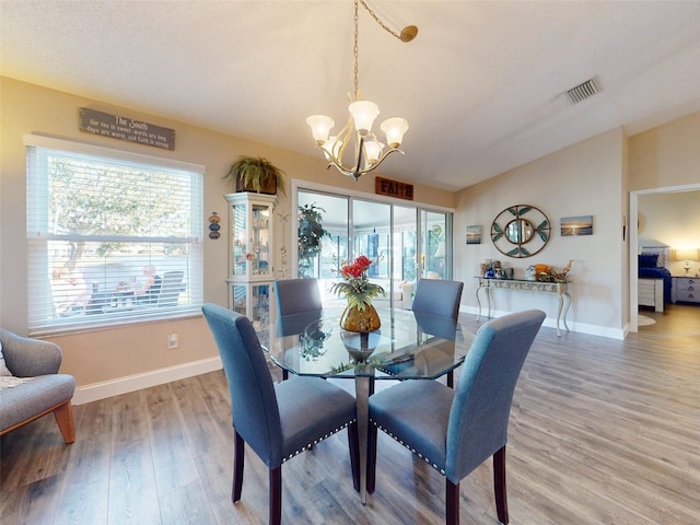 dining space with wood-type flooring and a chandelier