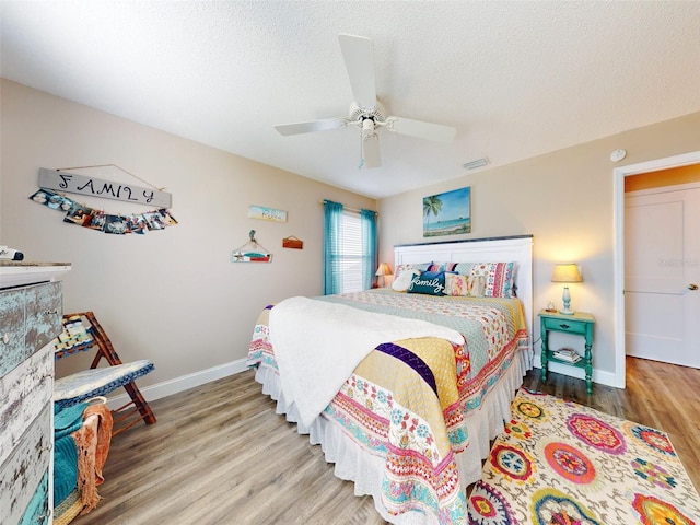 bedroom featuring hardwood / wood-style flooring, a textured ceiling, and ceiling fan