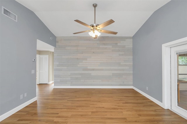 empty room with light hardwood / wood-style flooring, ceiling fan, and vaulted ceiling