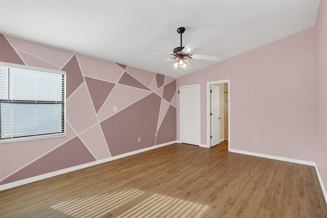 spare room with ceiling fan, wood-type flooring, and a textured ceiling