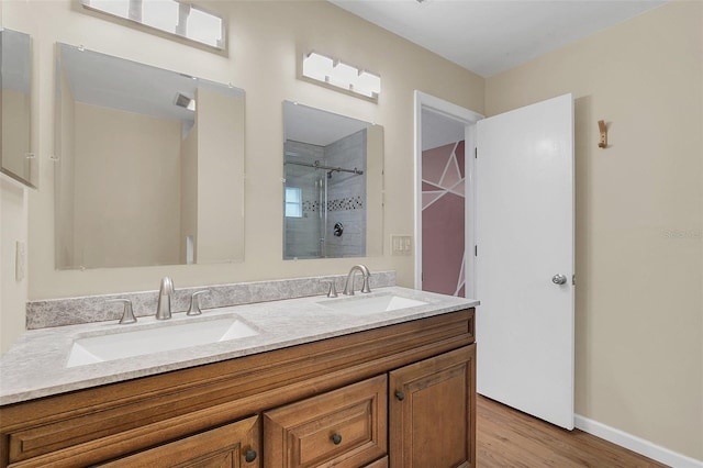 bathroom featuring hardwood / wood-style flooring, a shower with shower door, and vanity