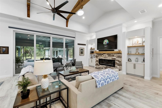 living room with a fireplace, lofted ceiling with beams, built in shelves, ceiling fan, and light wood-type flooring