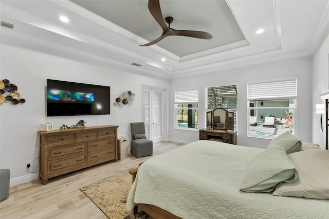 bedroom with ceiling fan, crown molding, light hardwood / wood-style floors, and a raised ceiling