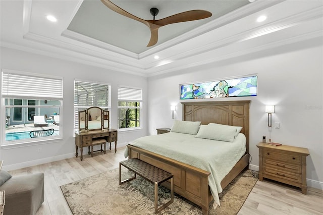 bedroom with a tray ceiling, light hardwood / wood-style flooring, ceiling fan, and ornamental molding