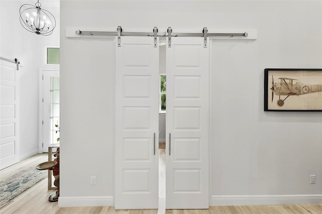 entryway with a notable chandelier, hardwood / wood-style flooring, and a barn door