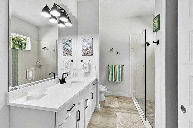 bathroom featuring walk in shower, toilet, vanity, and hardwood / wood-style flooring