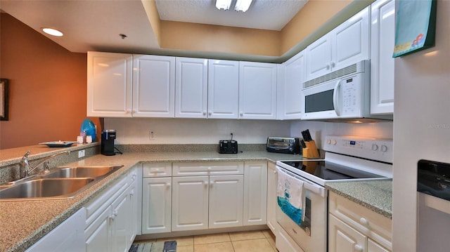 kitchen with white cabinets, white appliances, sink, and light tile patterned flooring