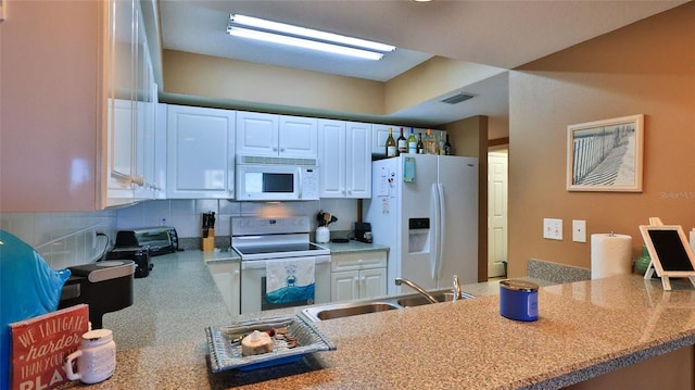 kitchen with white cabinets, white appliances, sink, and decorative backsplash