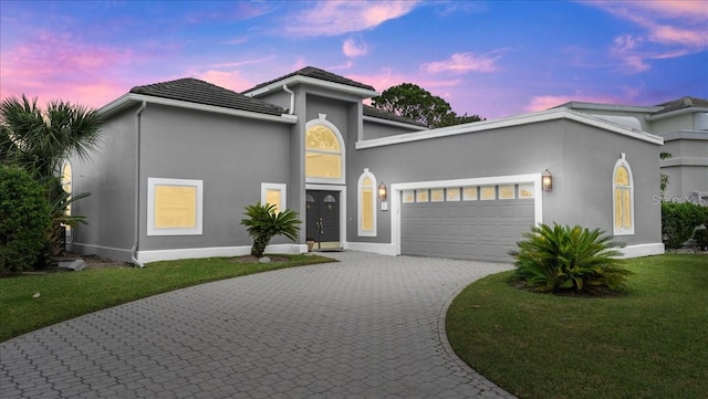 view of front of house with a garage and a yard