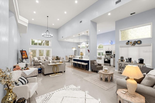 living room featuring a high ceiling, sink, and a notable chandelier