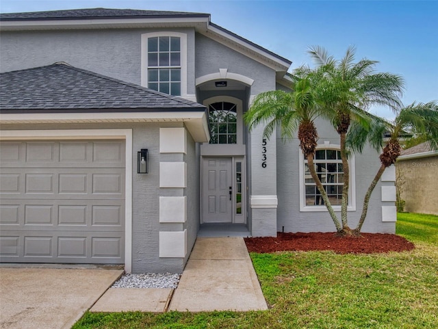 property entrance featuring a garage and a yard