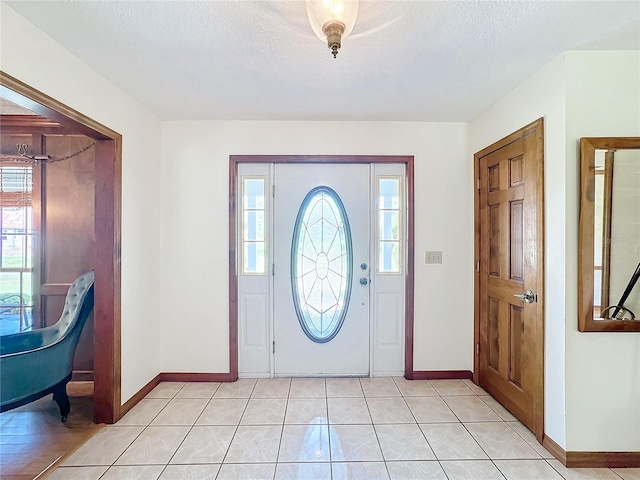 entryway with light tile patterned floors and a textured ceiling