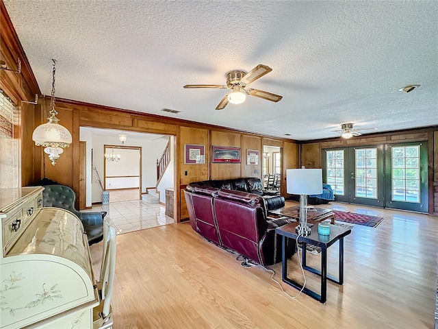 living room featuring french doors, light hardwood / wood-style floors, and a textured ceiling