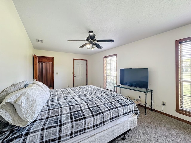 bedroom featuring carpet flooring, ceiling fan, and a textured ceiling