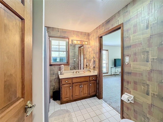 bathroom featuring tile patterned flooring, vanity, and a textured ceiling