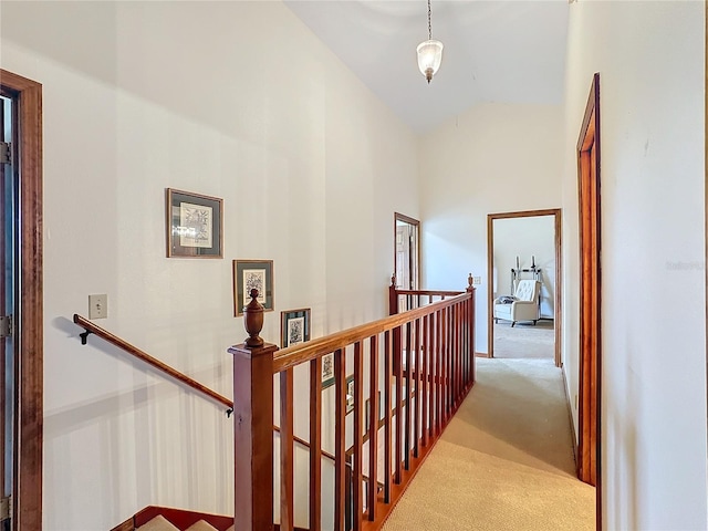 hallway featuring light carpet and high vaulted ceiling