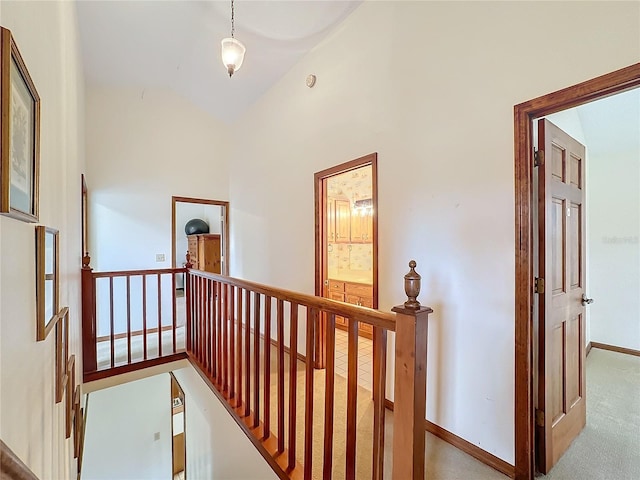 hall featuring light carpet and high vaulted ceiling