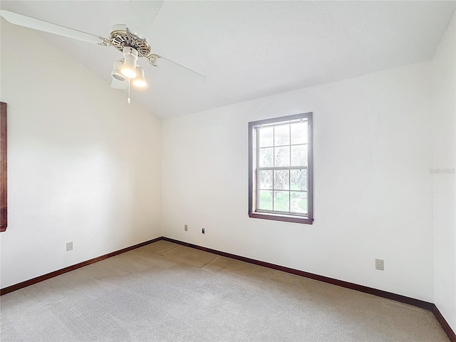 empty room featuring carpet, ceiling fan, and vaulted ceiling