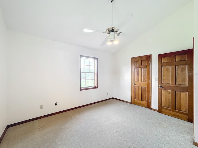 unfurnished bedroom with light colored carpet, vaulted ceiling, and ceiling fan