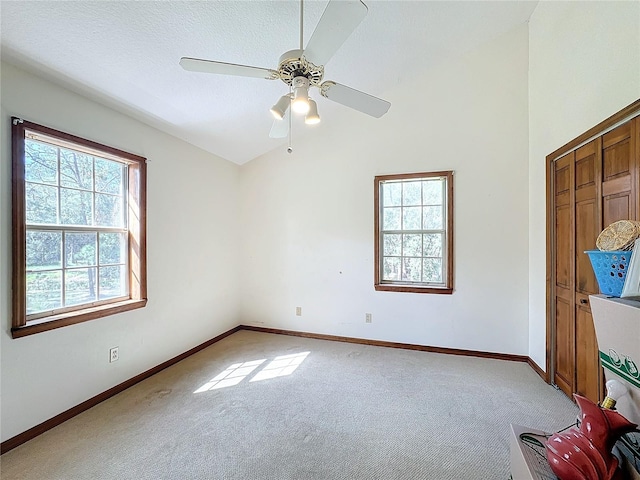 unfurnished bedroom featuring carpet, a textured ceiling, multiple windows, and ceiling fan