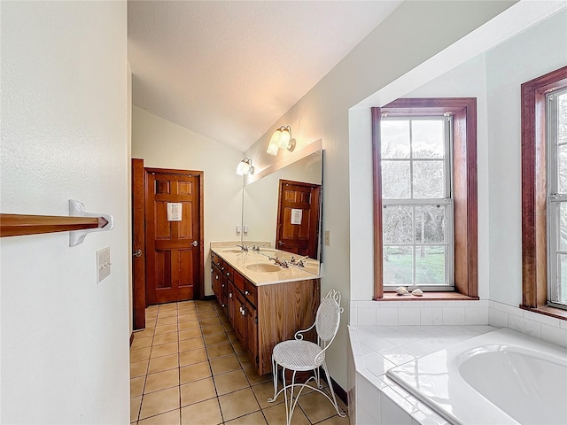 bathroom featuring tile patterned flooring, a healthy amount of sunlight, tiled tub, and vaulted ceiling