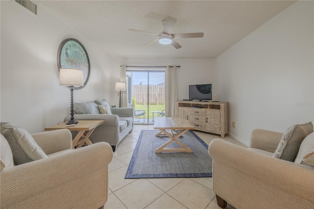 tiled living room with ceiling fan and a textured ceiling