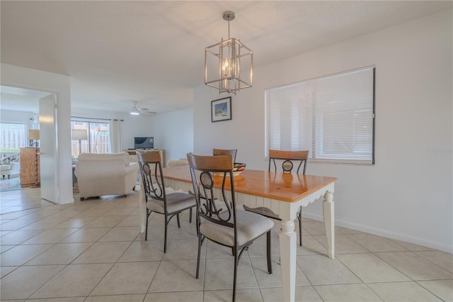 tiled dining area featuring ceiling fan with notable chandelier